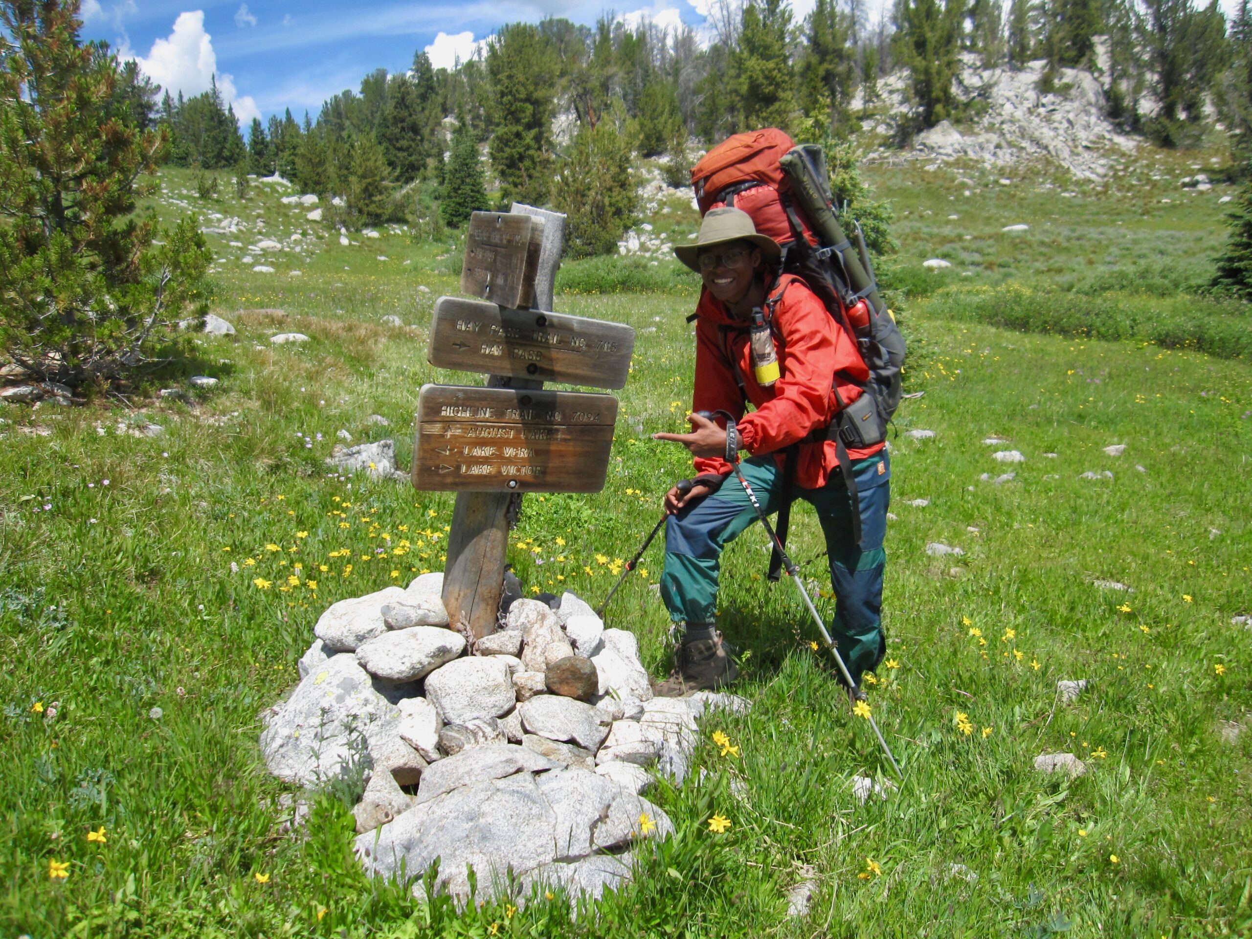 Victor High smiles and points to a trail sign