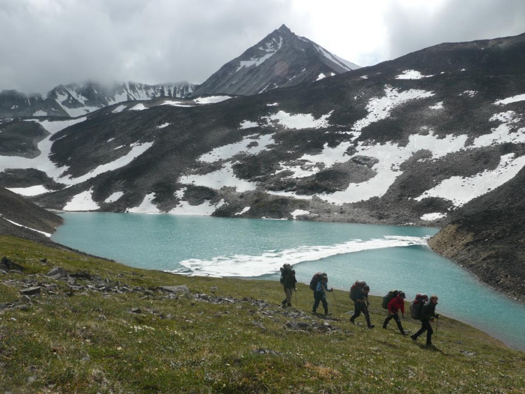 Group hiking along a lake in Alaska