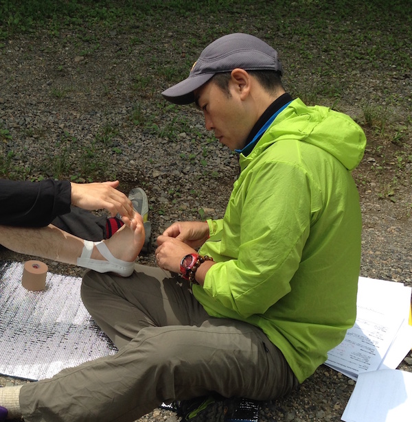 NOLS Wilderness Medicine student practices caring for a patient's ankle during a scenario 