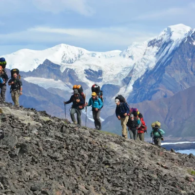 Students trek up the side of a mountain with the scenic Wrangell Mountains providing an epic backdrop. Credit: Tim Kelly