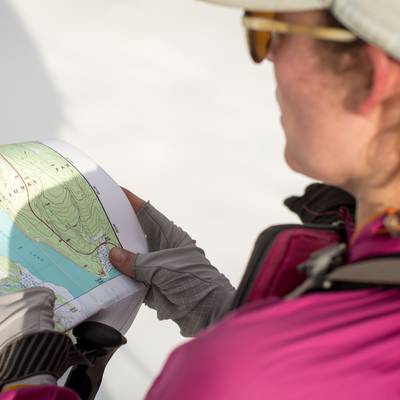 A course participant consults a map while skiing in Grand Teton National Park.
