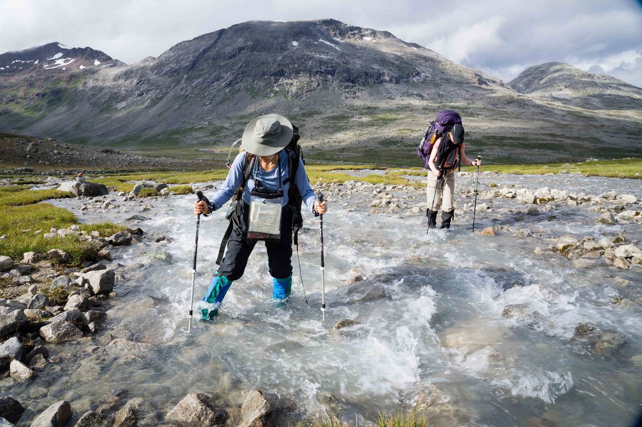 Two course participants crossing a river in the Scandinavian backcountry.