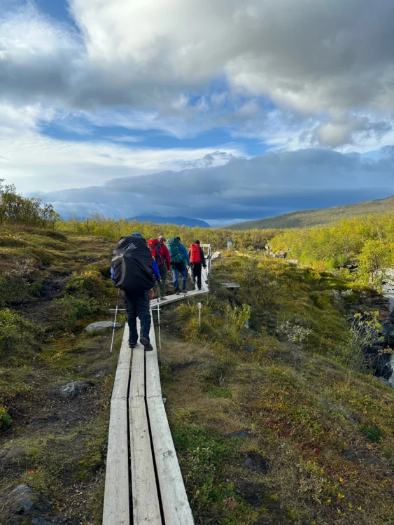 Hikers walk across a bridge in Sweden